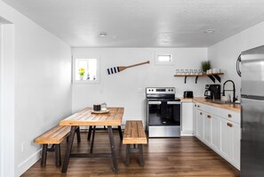 Een moderne keuken met houten aanrecht, een inbouwoven en een roestvrijstalen koelkast.
