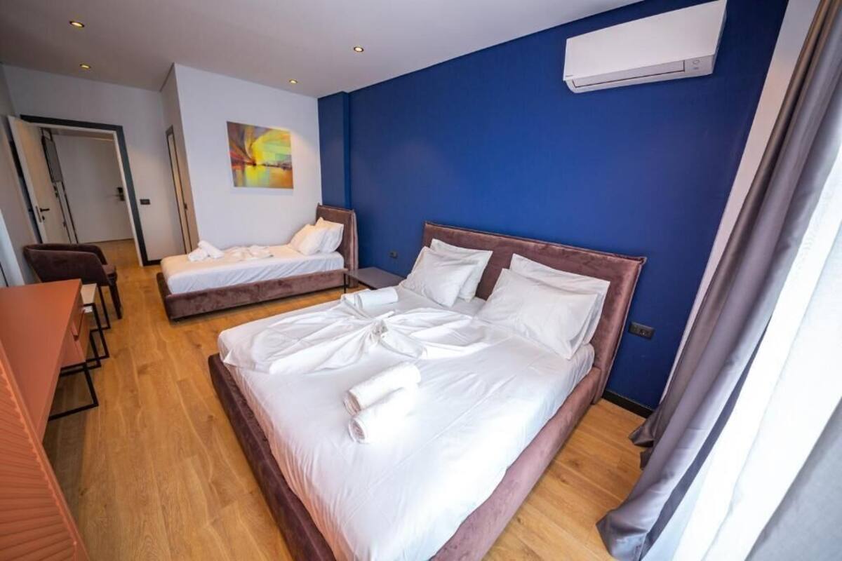 A hotel room with two beds, a desk, and a chair.