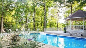 A swimming pool with a gazebo, surrounded by trees and lounge chairs. - Lake T Retreat - Sunset - Pool - Putting Green! (Northport)