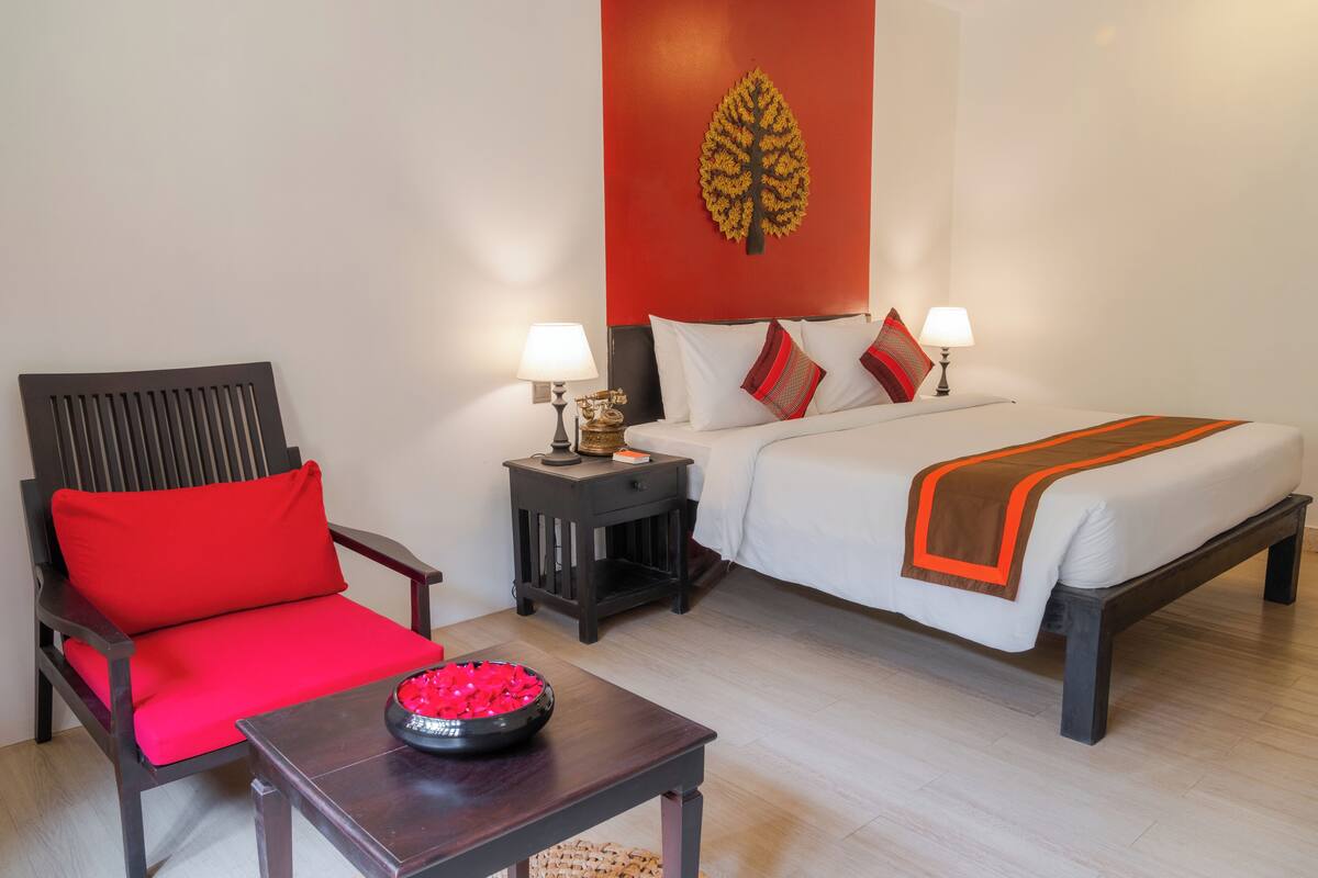 Una camera d'albergo con un letto, una sedia, un comodino e un tavolo.