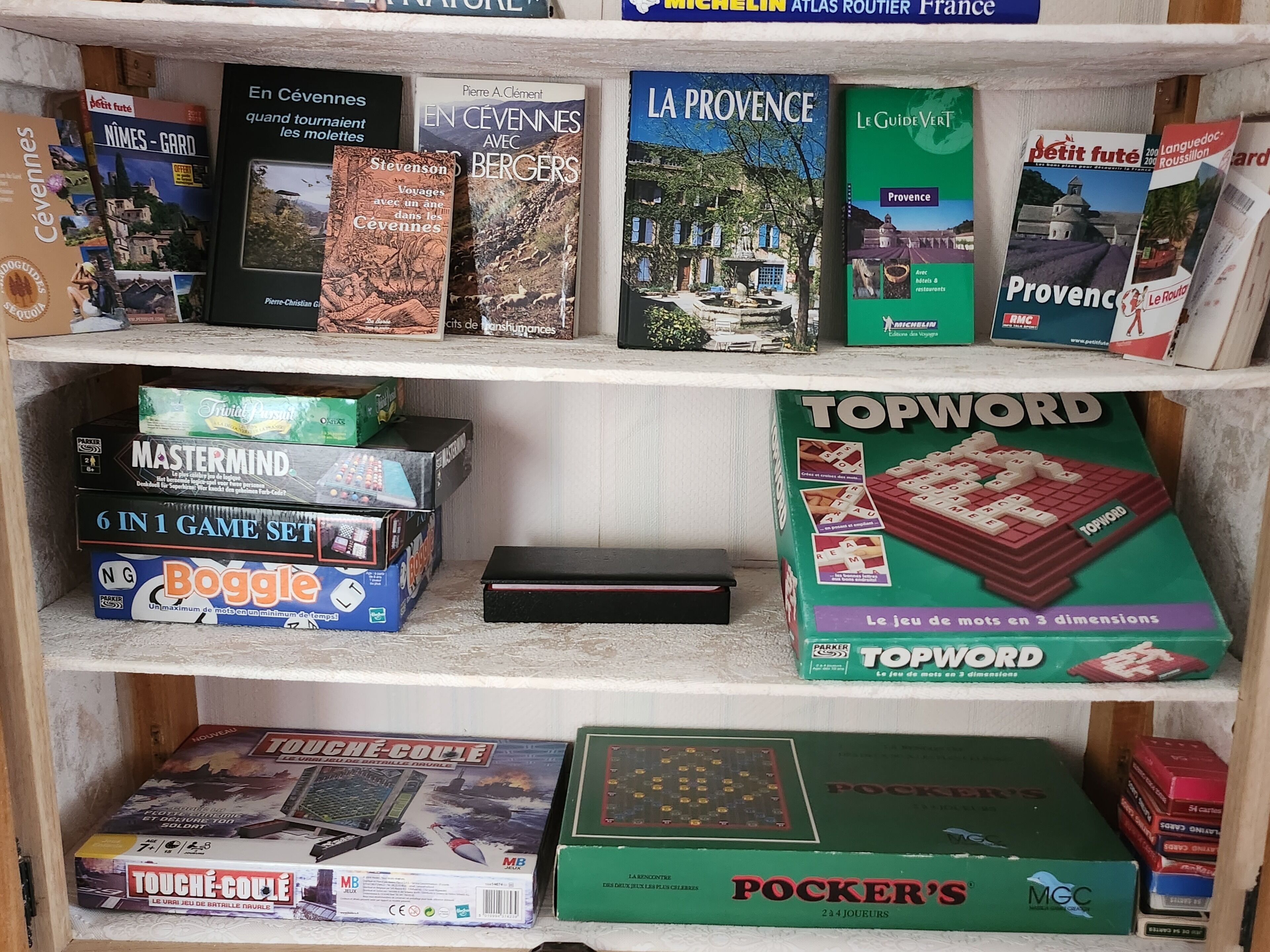 Une étagère contenant divers jeux de société et livres.