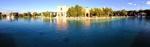 A large swimming pool with a building in the background. - Relais d'ourika (Oulad Dlim)