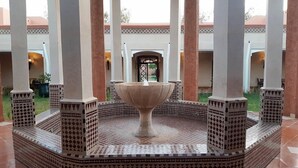 A courtyard with a central fountain, surrounded by columns and patterned flooring. - Relais d'ourika (Oulad Dlim)