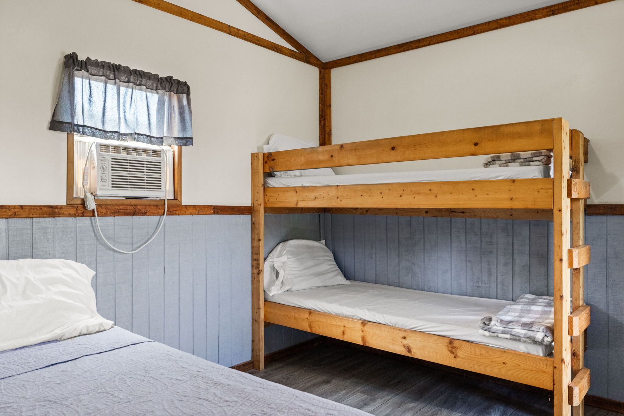 Uma cama beliche com janela e ar condicionado.