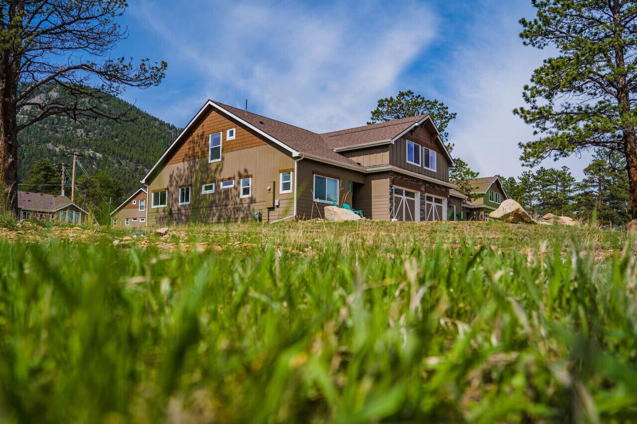 A two-story house with a sloped roof, multiple windows, and a front porch.