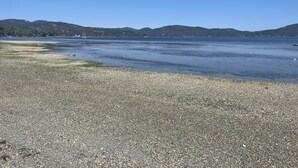A pebbled beach with calm water and distant hills. - 2 bedroom Oceanfront  - Billing spit (Sooke)