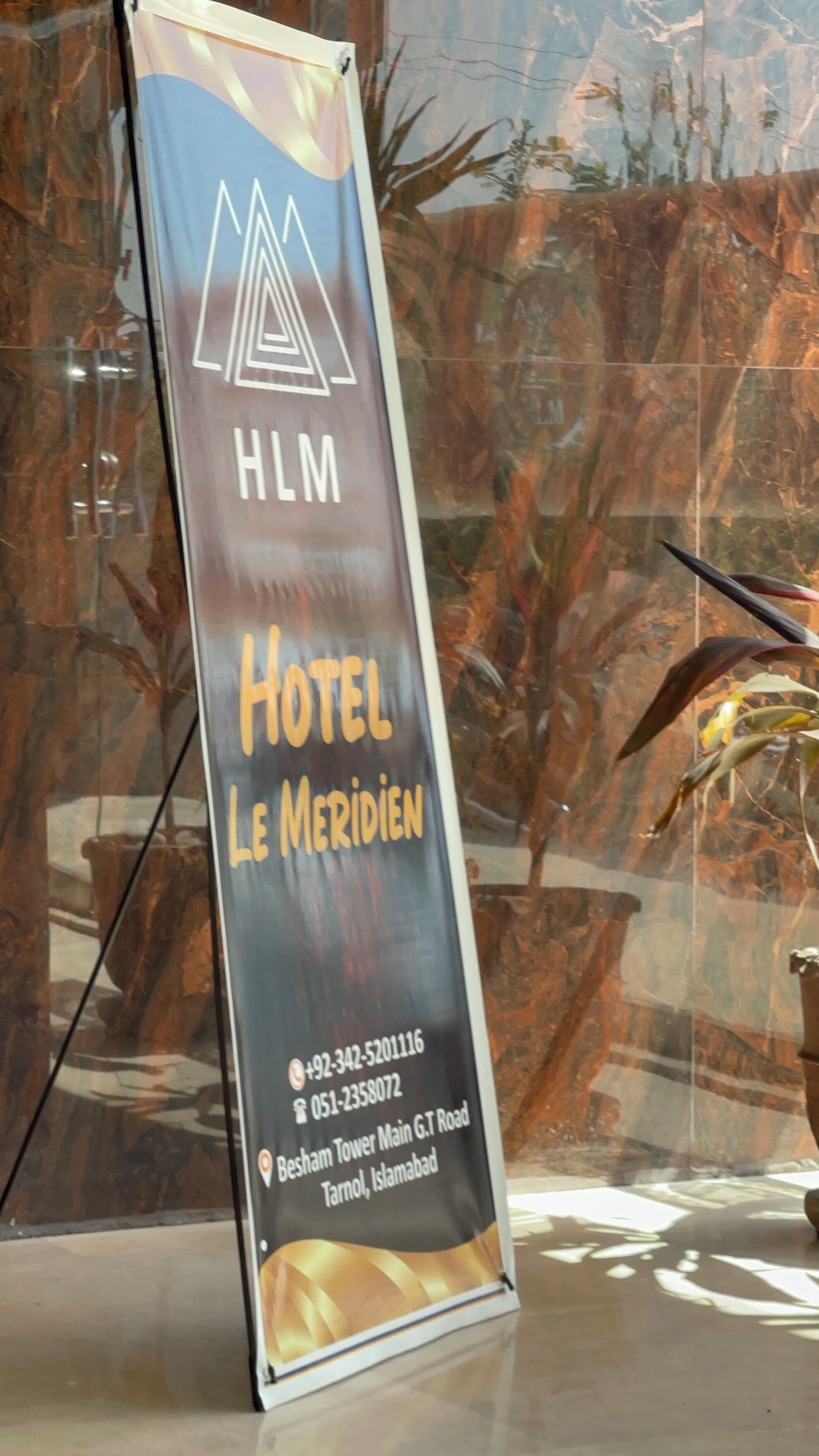 Señal de hotel con el nombre 'Hotel Le Meridien' e información de contacto.