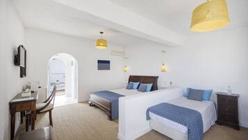 Une chambre d’hôtel avec deux lits, un bureau et une chaise. Il y a une grande fenêtre et une porte qui donne sur l’extérieur.