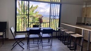 A modern kitchen with a large window overlooking a tropical landscape. - Berakah Spa & Rooms (Guatapé)