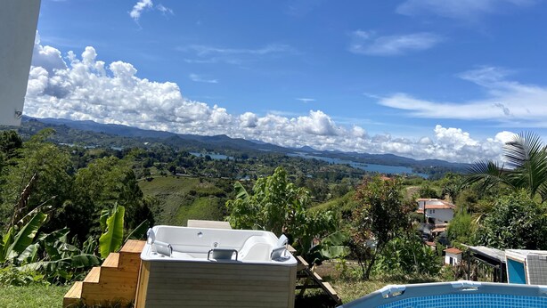 A view of a mountainous landscape with a pool and hot tub in the foreground. - Berakah Spa & Rooms (Guatapé)