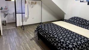 A bedroom with two beds, a bathroom, and a view of the sky. - Berakah Spa & Rooms (Guatapé)