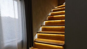 A staircase with wooden steps and built-in lighting. - ---Ammira Mare--House near sea with pool (Malevizi)
