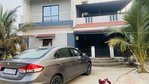 A modern two-story house with a car parked in the driveway.