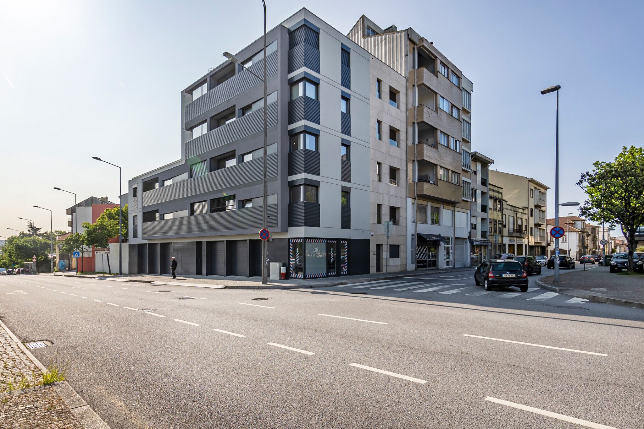 A multi-story building with a modern architectural design, featuring a mix of balconies and large windows.