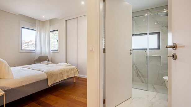 A modern bedroom with a bed, bedside tables, and a large window. - Nomads Lux - 2BDR Parking Flores Porto (Porto)