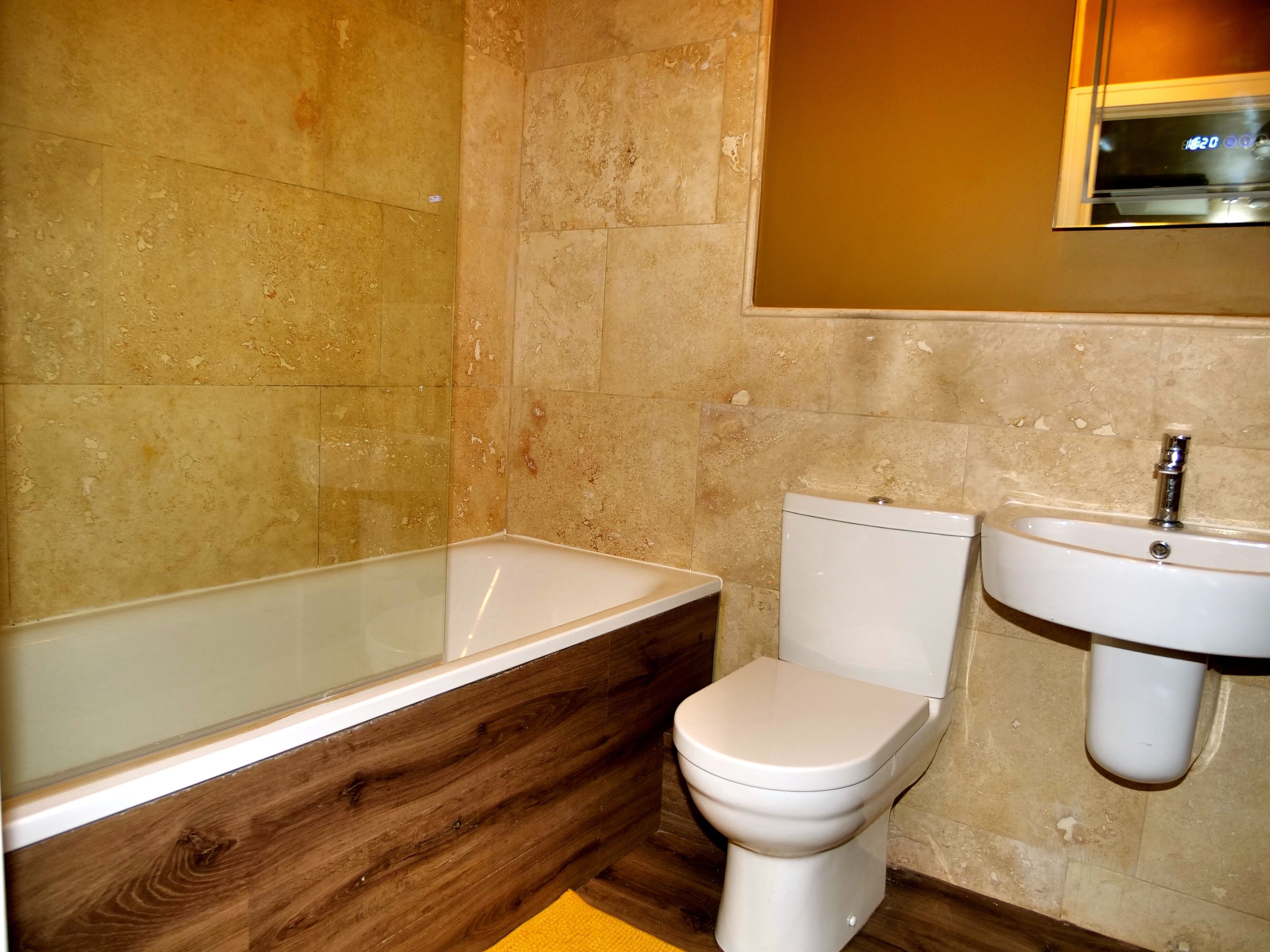 A bathroom with a bathtub, toilet, and sink.