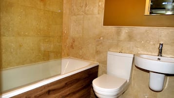 A bathroom with a bathtub, toilet, and sink.
