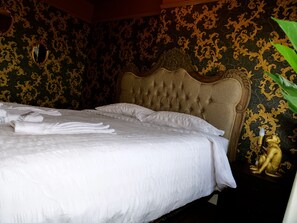 A neatly made bed with white linens and towels, a tufted headboard, and a gold statue on a nightstand. - Deluxe Versace Styled Apartment (South Yorkshire)