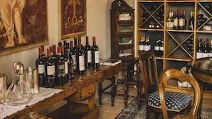 Una bodega con estantes de madera, una botellera y una mesa de comedor con sillas.