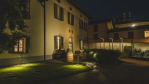 Un patio con un edificio, un banco y un farol.