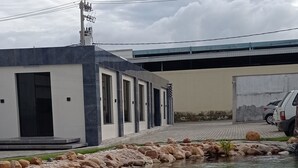 Un edifici modern amb piscina, envoltat de roques grans i vegetació.