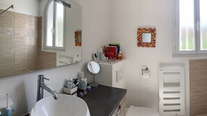 A bathroom with a sink, mirror, and shower.