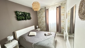 Una camera da letto moderna con un letto grande, un comodino, una lampada a parete e un decoro murale.