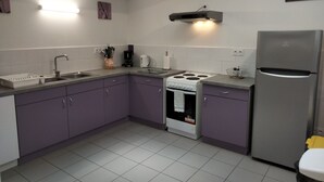 A kitchen with a stove, sink, and refrigerator. - Gîte de Groupes de 2 à 12 Personnes (Guillon-Terre-Plaine)