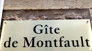 A sign with the text "Gîte de Montfault" mounted on a stone wall. - Gîte de Groupes de 2 à 12 Personnes (Guillon-Terre-Plaine)