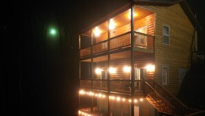 Una baita a più piani in legno, con balconi e una scala.
