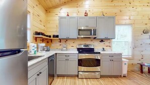 Una cucina moderna con mobili grigi, elettrodomestici in acciaio inossidabile e pavimento in legno.