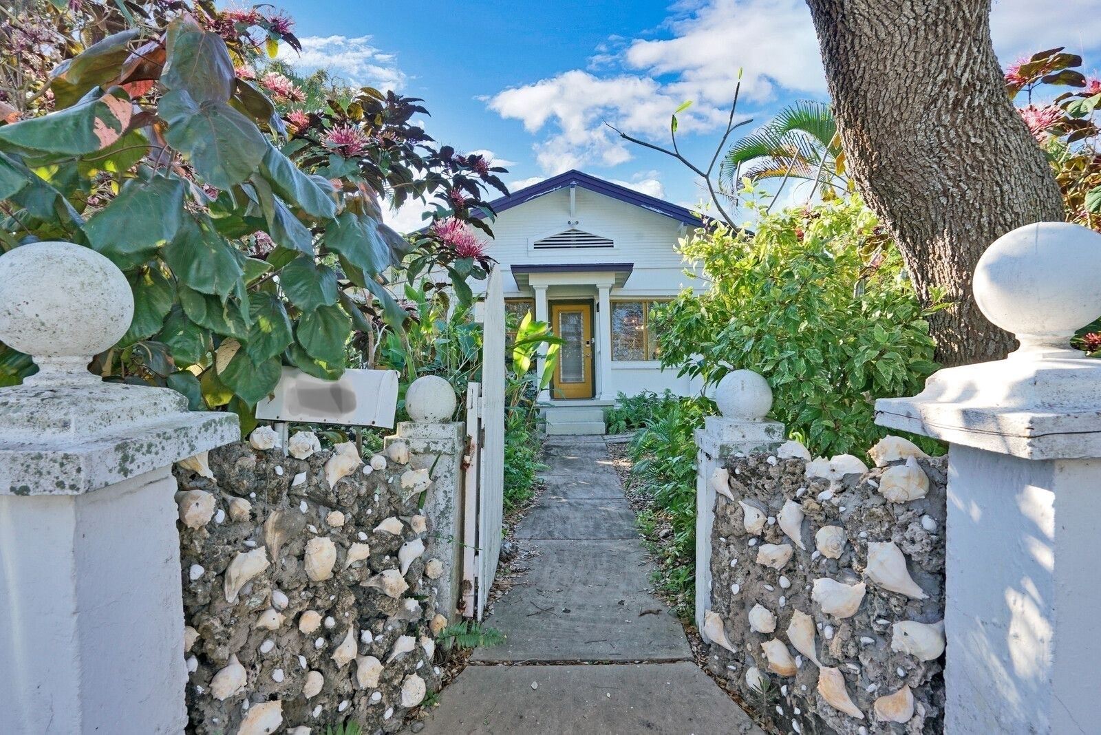 Hemingway-style house +porch  in lush garden setting block from water