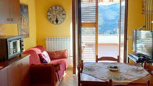 Una cocina acogedora con comedor, un reloj en la pared y vistas al exterior.