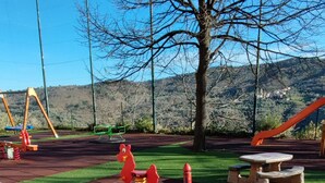 Un parque infantil con columpios, un sube y baja y una estructura para escalar.