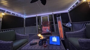 A covered outdoor area with wicker furniture, a ceiling fan, and a laptop displaying 'ESSENCE'. - MC (Modern Country) LIVING (Elizabethtown)