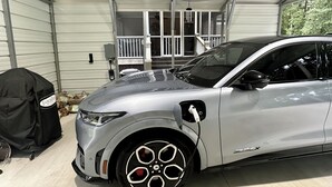 A silver SUV parked in a covered garage with a grill and a power outlet visible. - MC (Modern Country) LIVING (Elizabethtown)