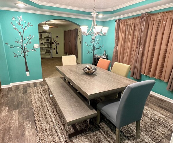 Un comedor con mesa de madera, sillas y banco.