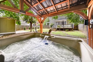 A hot tub under a wooden pergola with a backyard view. - Elizabeth City Vacation Rental: Gazebo w/ Hot Tub! (Elizabeth City)