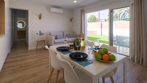 Un comedor con una mesa preparada para dos, un sofá y vistas al exterior.