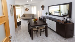 A modern kitchen with a dining table, chairs, and a large mirror. - FUENTE Beachfront Apartment (Salou)
