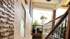 A staircase with a stone floor leading to a balcony with a wrought iron railing. - Riad Les Miroires (Marrakech)