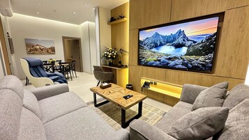 Deluxe Apartment, 3 Bedrooms | Living area | 75-inch Smart TV with satellite channels, offices