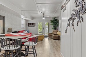 Relax in this inviting living area with a dining table, sofa, and potted plant, surrounded by a decorative metal art piece and a sign reading 'TIBERON LAKE'.