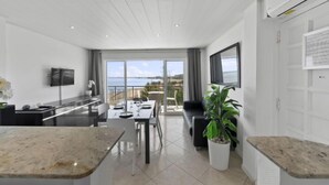 A modern kitchen with a dining area, large windows, and a view of the sea. - Medusas by Interhome (Dénia)