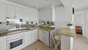 A modern kitchen with white cabinets, a granite countertop, and a built-in oven. - Medusas by Interhome (Dénia)