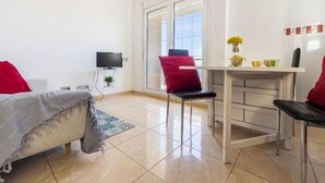 A modern bedroom with a bed, a TV, a desk, and a chair. - Apartment Narcis by Interhome (L'Ampolla)