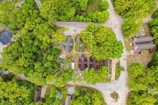 An aerial view of a property with a central building surrounded by dense greenery, a paved driveway, and a small parking area. - #1 Requested A Frame at Table Rock is Back! (Lampe)