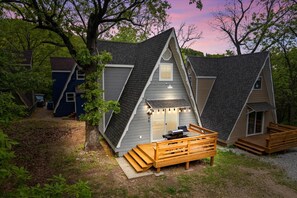 A modern, A-frame style cabin with a deck and outdoor seating area, surrounded by trees. - #1 Requested A Frame at Table Rock is Back! (Lampe)