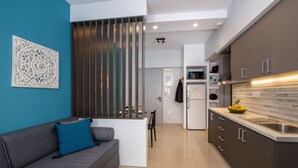A modern kitchen with dark cabinets, a white countertop, and a stainless steel sink. - City Centre Gem in Chania (Χανιά)