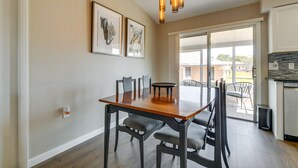 A dining area with a wooden table, chairs, and a ceiling light fixture. - Florida Vacation Rental w/ Enclosed Porch! (Beverly Hills)